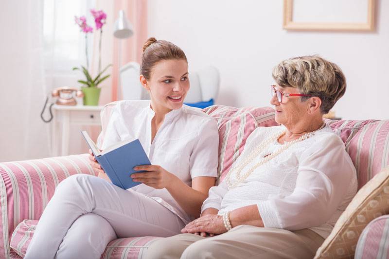 WLC resident and caretaker reading a book