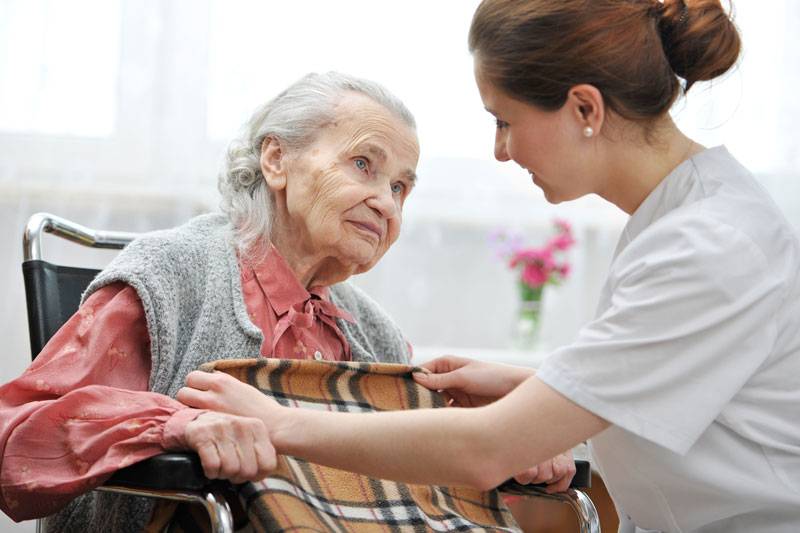 WLC nurse giving resident a blanket